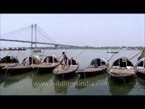 Boats tied to the Outram Ghat down against the backdrop of a picturesque Vidyasagar Setu
