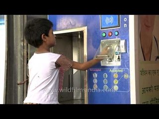 Young boy uses Swajal water vending machine: Rs. 1 per litre