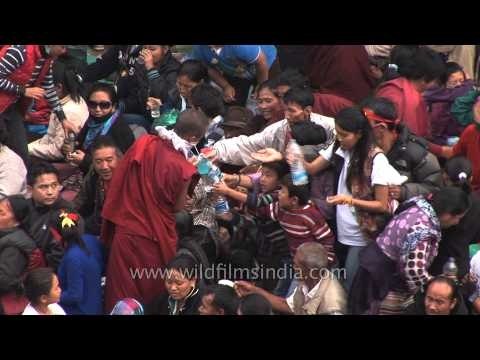 Monk distributes holy water among Tibetan devotees - Kalachakra Bodhgaya