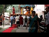 Devotees wait to carry the idols of deities inside the temple