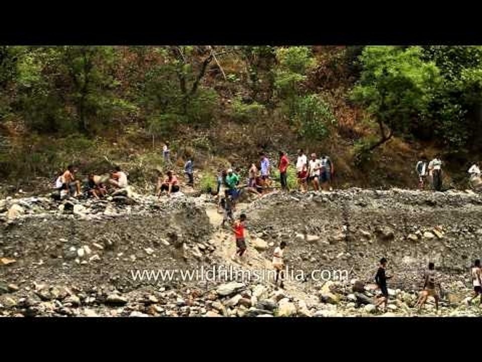 People walk on makeshift bridge to cross Aglar river