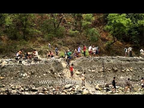 People walk on makeshift bridge to cross Aglar river