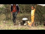 Man arranging stones to create three stone fire for cooking
