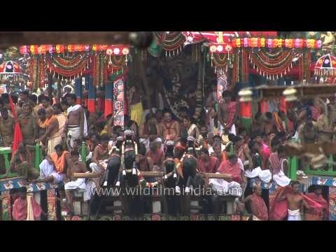 Hindu priests sit on the chariot as devotees pull chariot