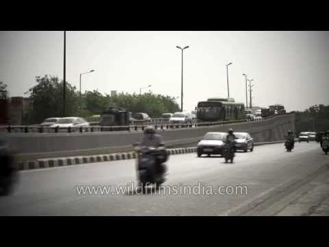 Vehicles moving along a busy road in New Delhi