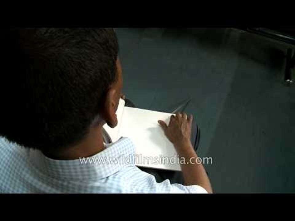 Visually-challenged man reading with Braille script: Central braille press