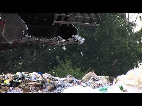 Tractor crane moving waste paper at a recycling yard