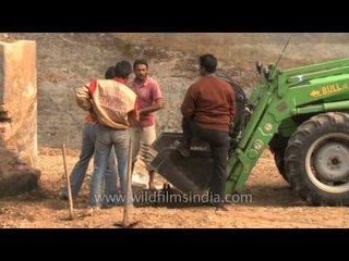 Men loading left out silage in bulldozer