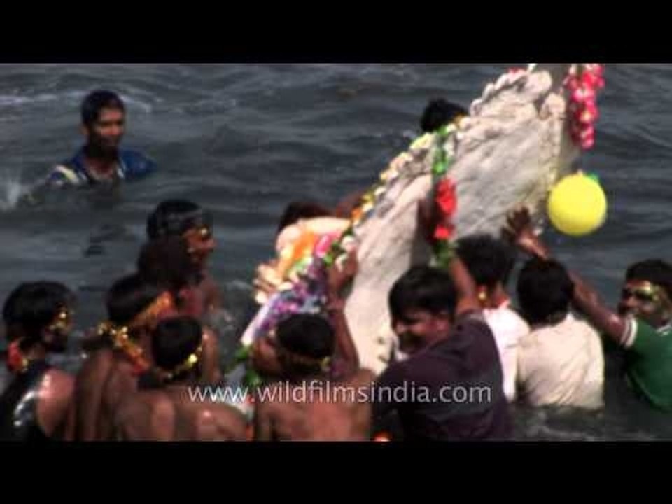 Devotees immerse a Ganesh idol in the Yamuna river