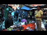 Indian youth buying shoes from Sunday market at Daryaganj