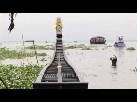 Man bathes next to his new Snake Boat in the backwaters of Kerala