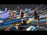 A fleet of fishing boats left idle along a beach in Kanyakumari