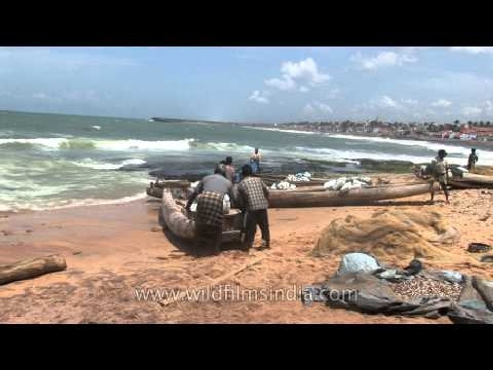 Fishermen bring traditional boat to the shore at Kanyakumari
