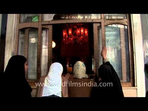 Raising their hands in prayer - Muslim women outside Makhdoom Sahib Shrine