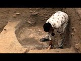 Man sweeping off the loose soil during excavation at Purana Qila
