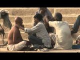 Men getting their heads shaved on the ghat along the Ganga