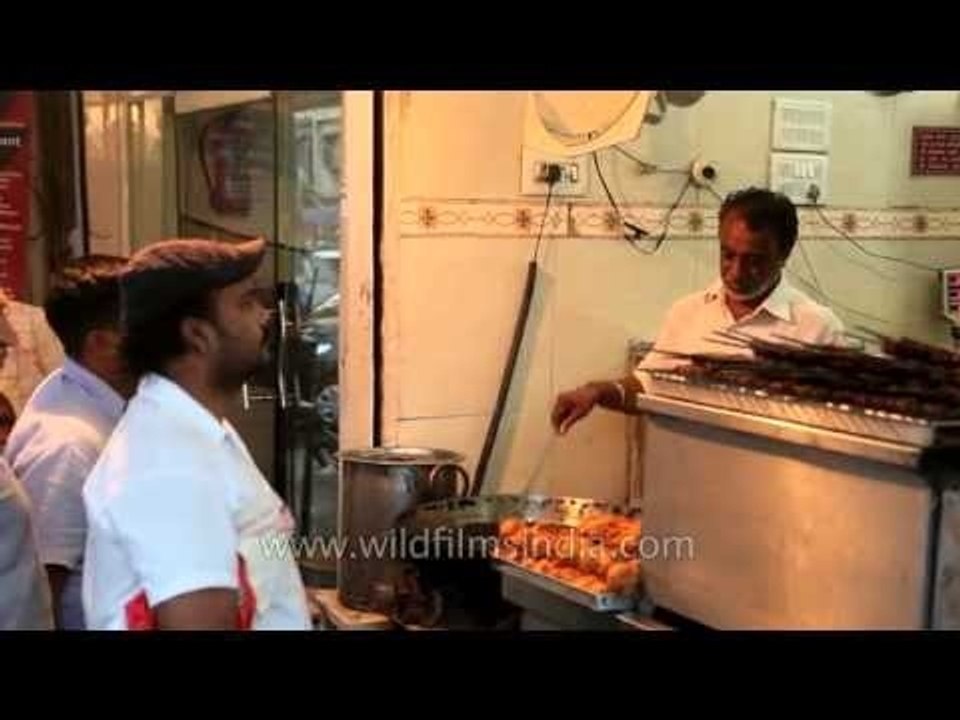 Cook takes orders for fried fish at popular urban street kitchen