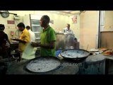 Enormous meat skewers cook in the tandoor: a cylindrical oven