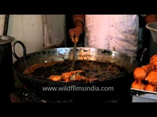Head cook checks if his fillets are cooked at his Indian restaurant