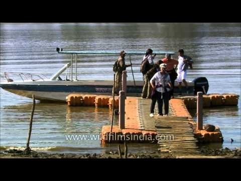 Tourists disembark onto a river jetty in Satpura National Park