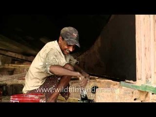 Smiling workers painting the large fishing boat - Kochi