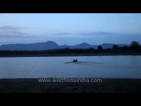 Visitors in motorboat sailing over Denwa River