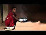 Woman cooking food in a traditional stove (chulha)