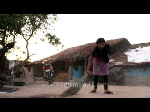 Woman sweeping her house at Madai village, Satpura