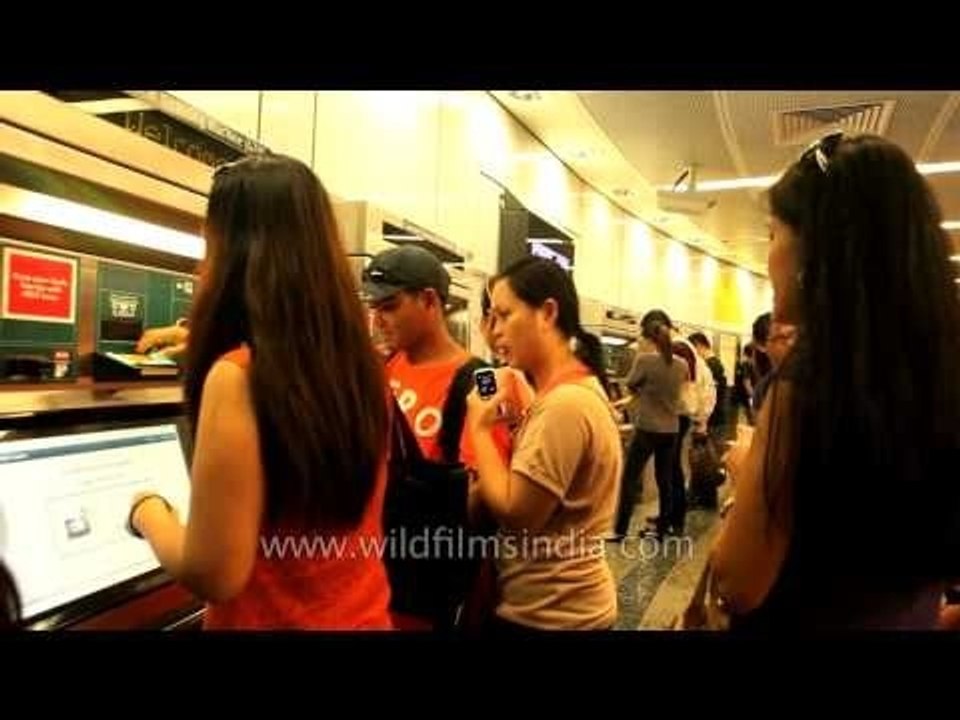 Commuters in queue to recharge smart cards, Singapore MRT