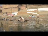 People drying clothes on the banks of river Ganges - Varanasi