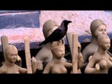 Crow sits on freshly-made women's figures at Kolkata's Kumortuli