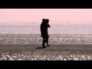 People walking on the sandy mudflats of Bakkhali beach