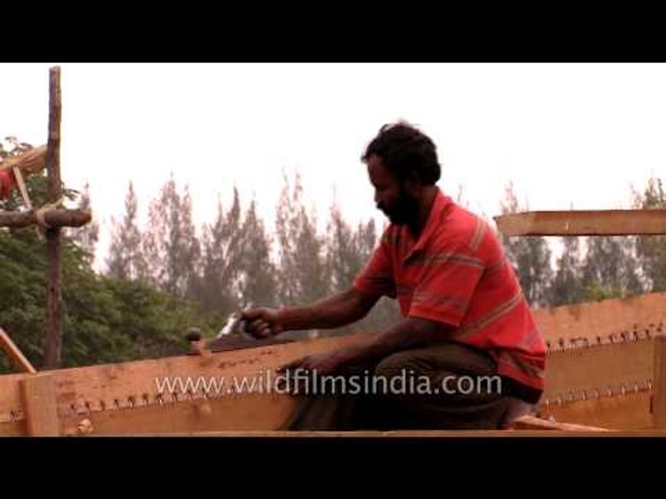 Carpenters carving a wooden boat in Bengal