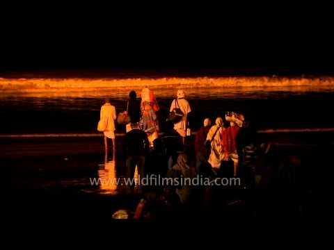 Pilgrims stand near the holy Ganges