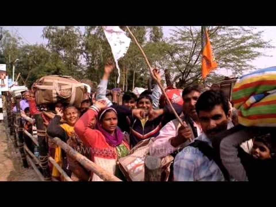 Pilgrims of Gangasagar mela waves at the camera