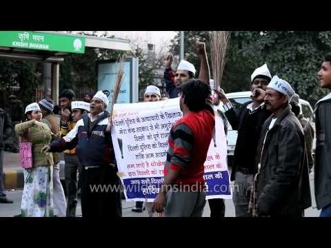 AAP supporters in white cap, waving broom in New Delhi
