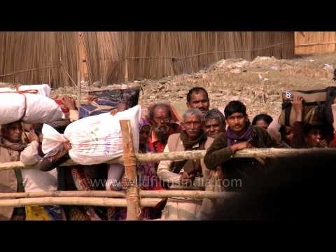 Visitors attending Gangasagar mela waves at the camera