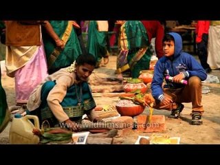 Man distributes ladles made of coconut shell to women making pongal
