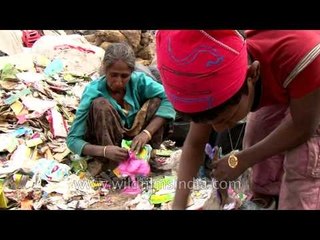 Indian woman and boy sort paper and plastic from garbage