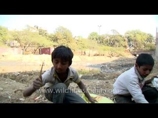 Teenagers searching through the rancid waste for any recyclable materials