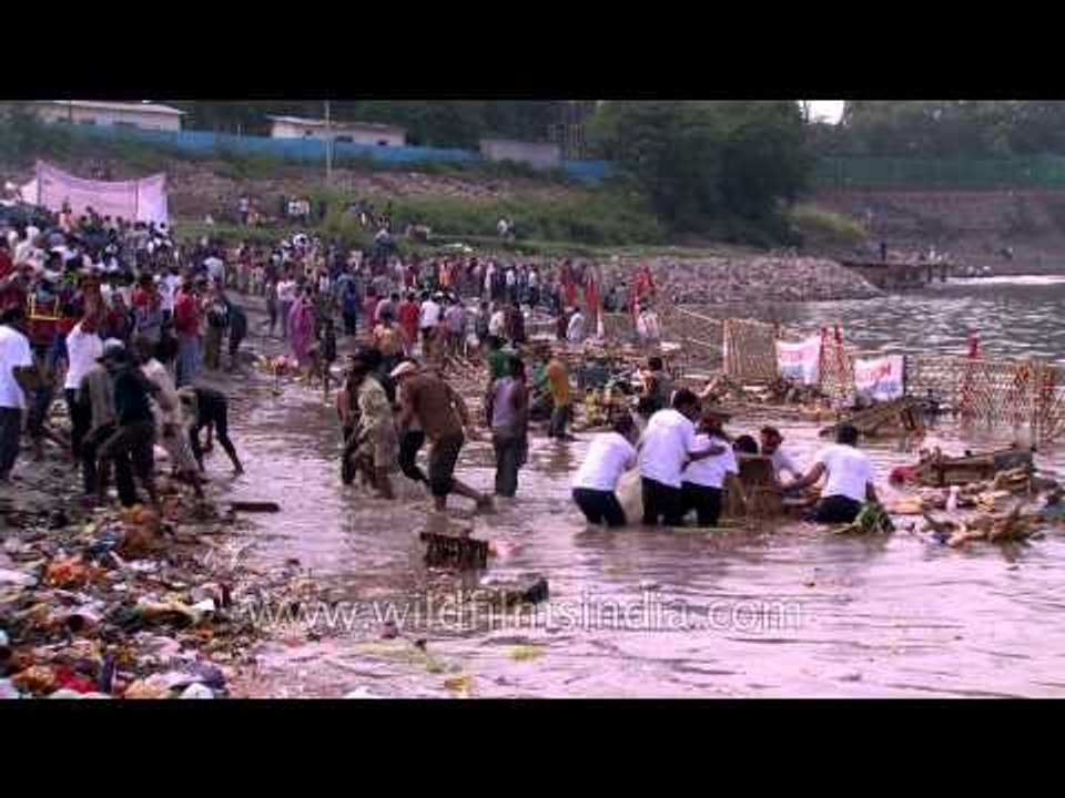 Devotees submerging an idol of Hindu goddess Durga in the river Yamuna