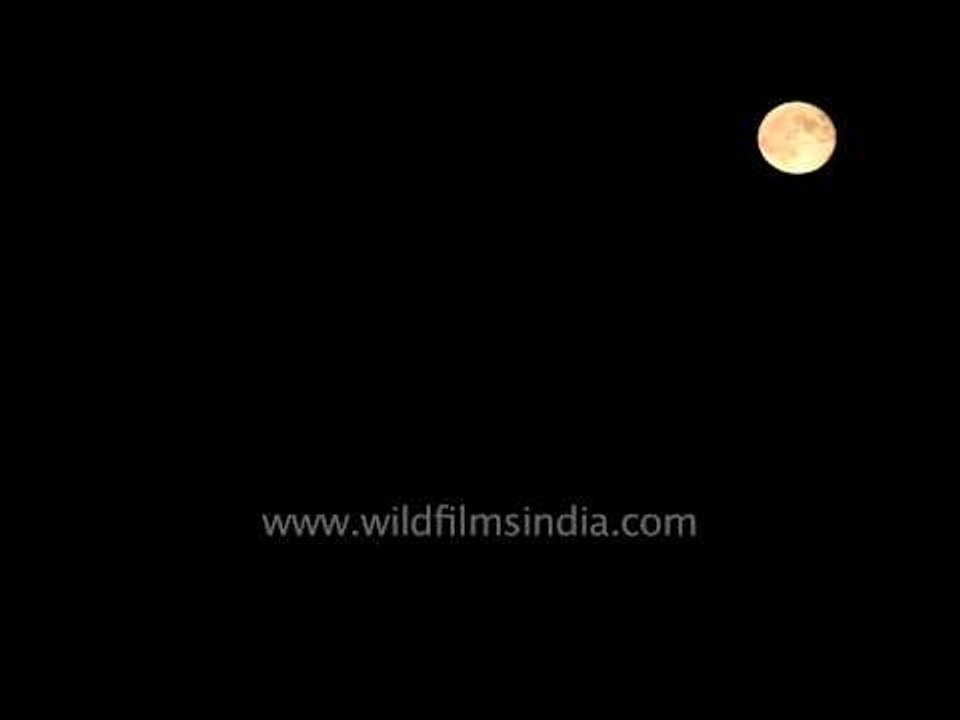 Moon moving behind dark clouds
