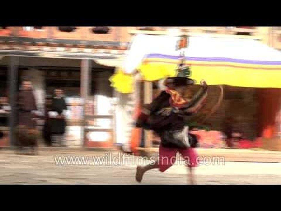 Dancers in colourful brocade long dress with black hats performing at Monastery in Bhutan