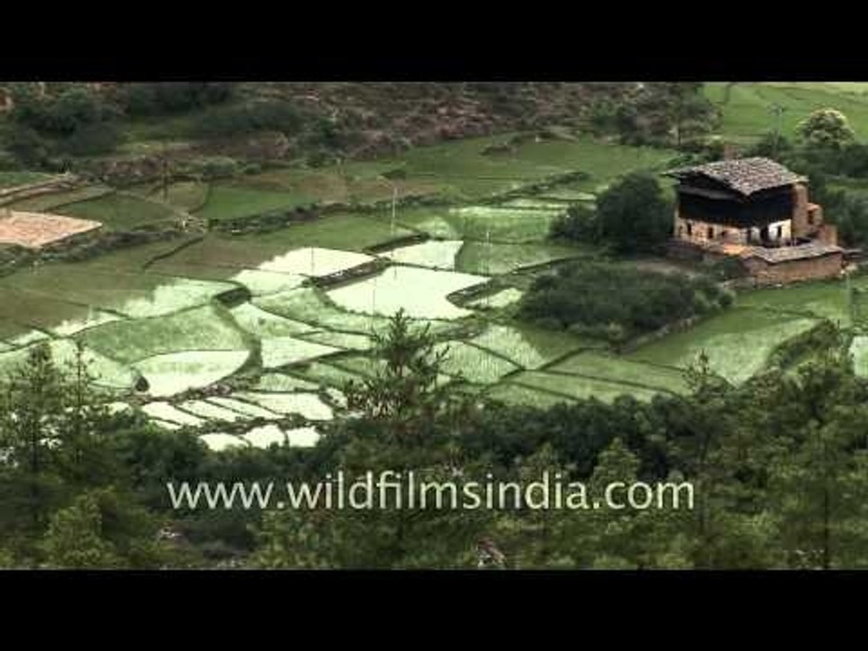 Mother and child revolve prayer wheel in Paro valley, Bhutan