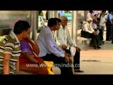 Passengers awaiting the arrival of a bus at a bus stop