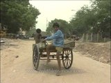 Poor children ride a cycle rickshaw used by their father