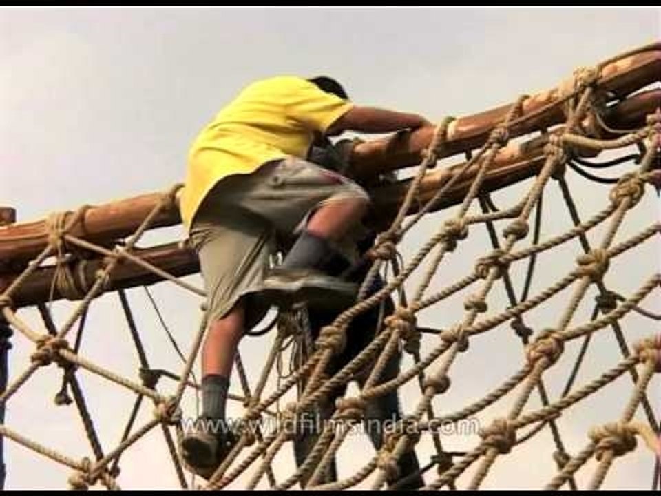 Children climbing web of rope