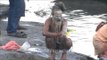 A naga sadhu smears his body with ash after bathing in the River Ganges at Varanasi