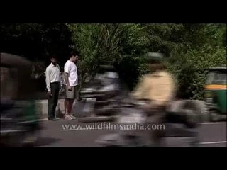 The man in white is scared to cross the road at New Delhi