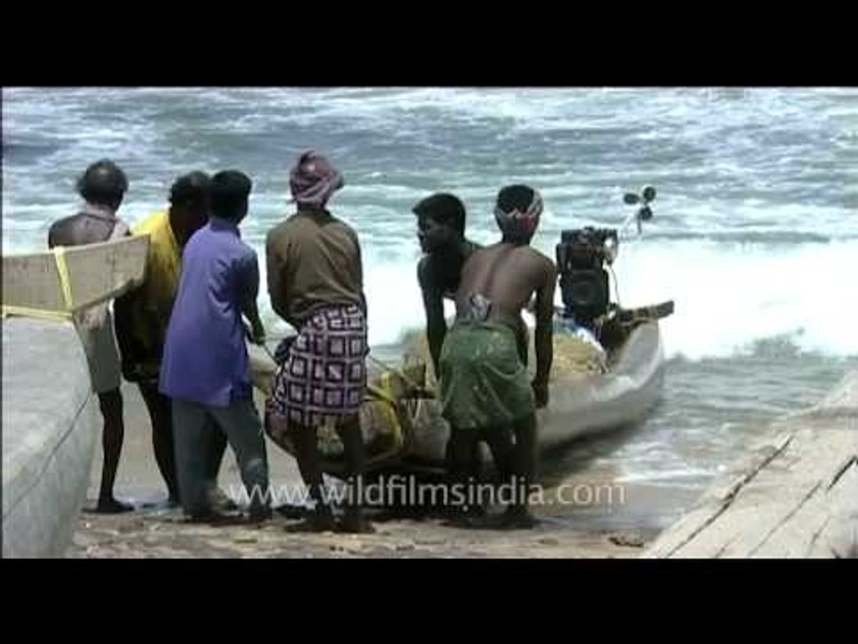 Fishermen pulling the boat off the shore
